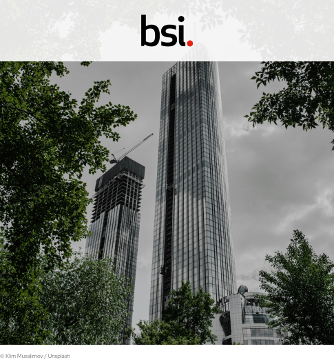 bsi cover picture showing a skyscraper with trees surrounding it. Up top is the BSI logo on a white rectangle